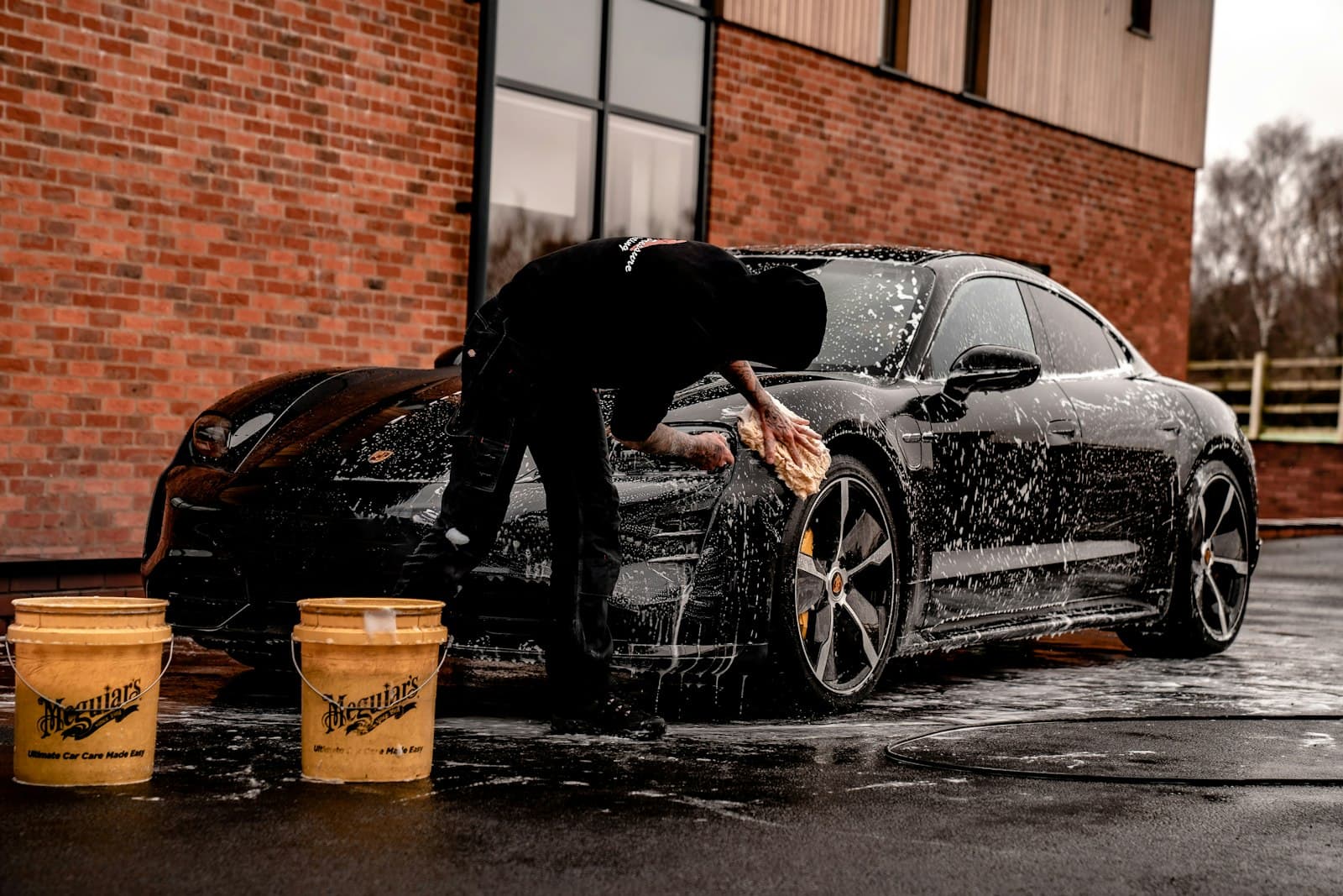 A detailer hand-washing a car with foam