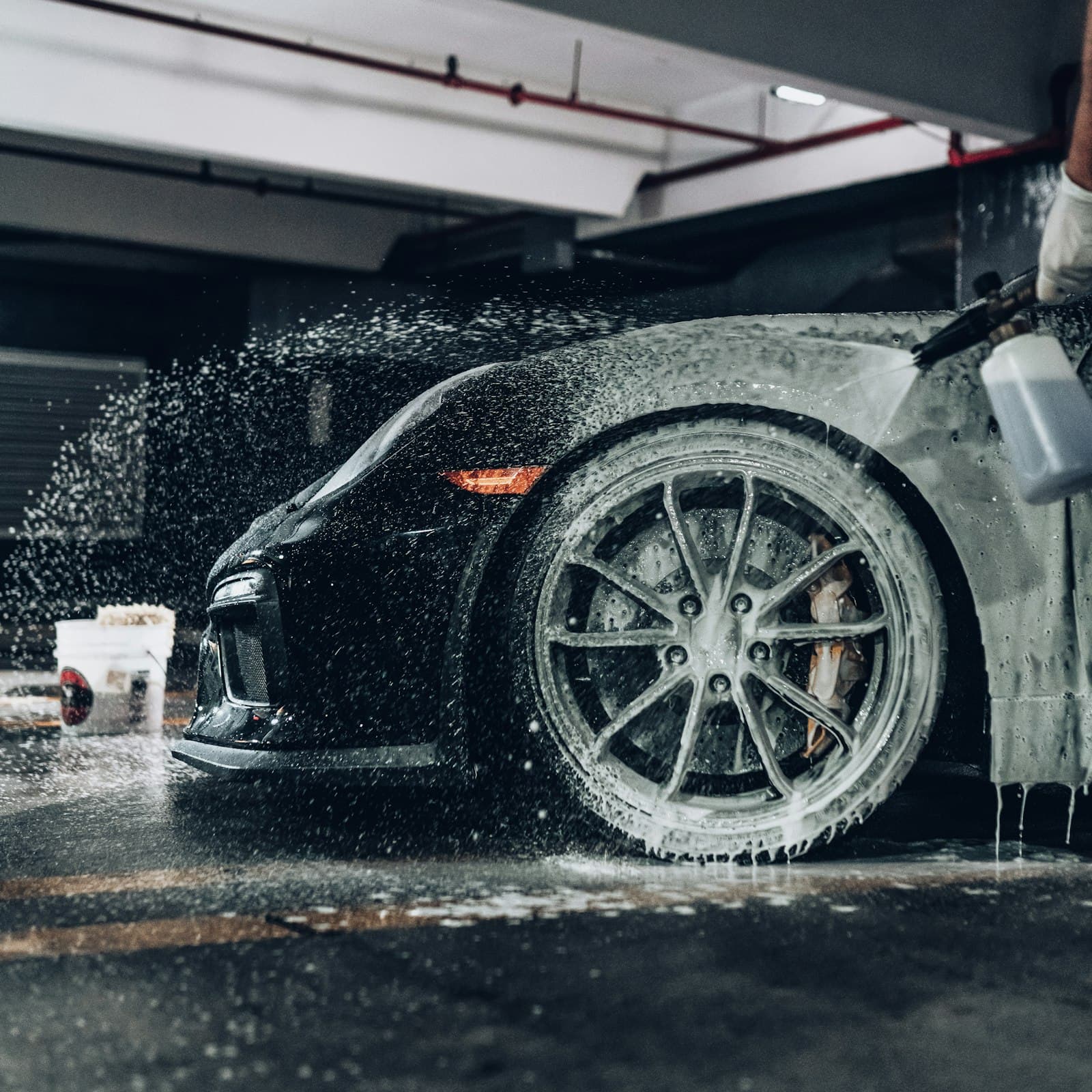 A car wheel and arch being cleaned with foam