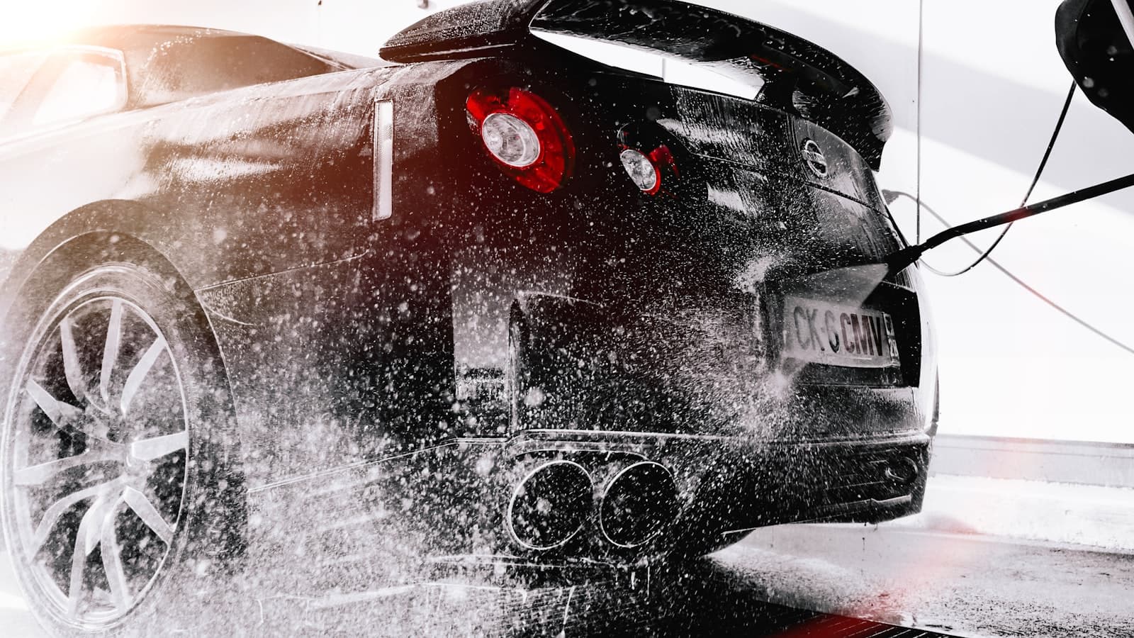 Water spraying off the rear of a car during a wash