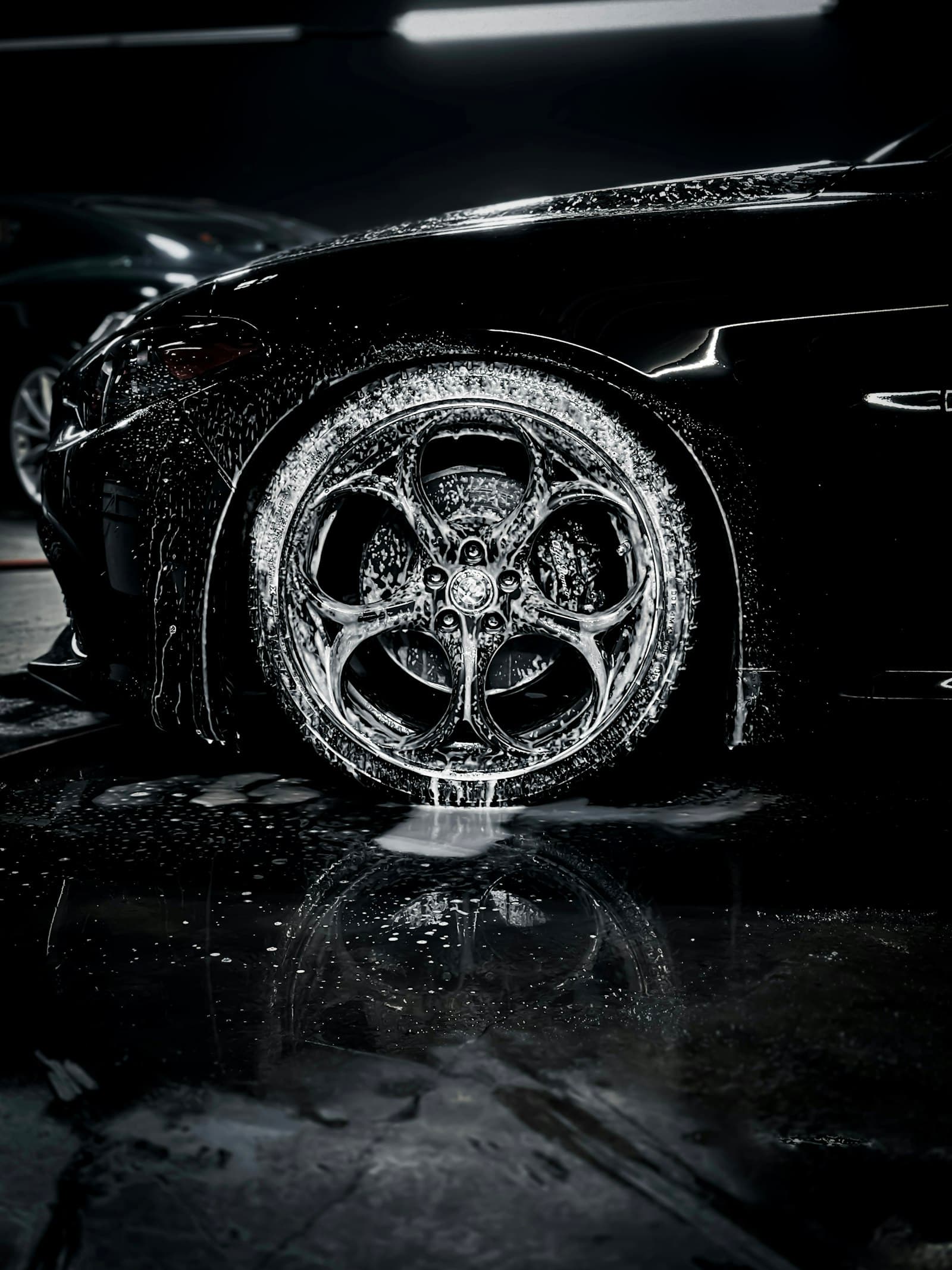 A wheel covered in cleaning foam, lit dramatically